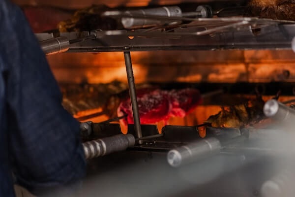 Brazilian churrascaria rotisserie grill with charcoal smoke