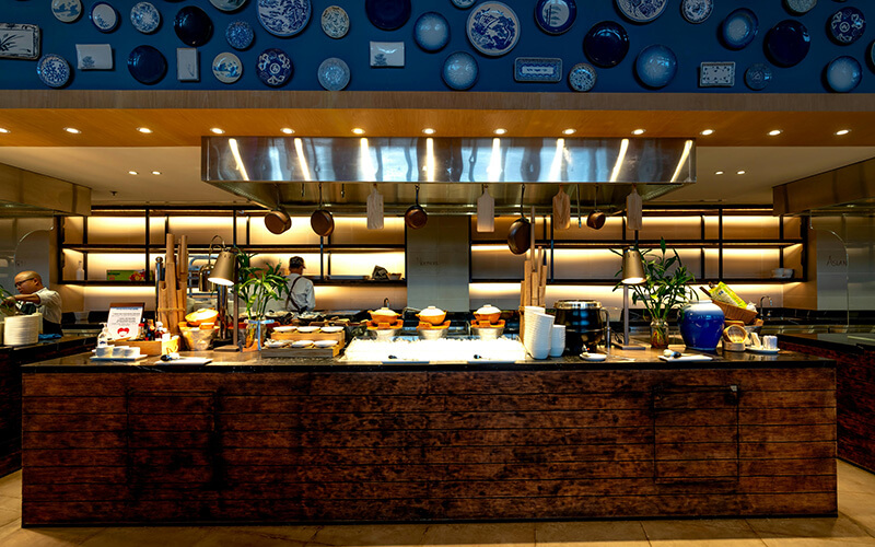 Open-plan food court with freestanding island cooking stalls and distributed ESP zones